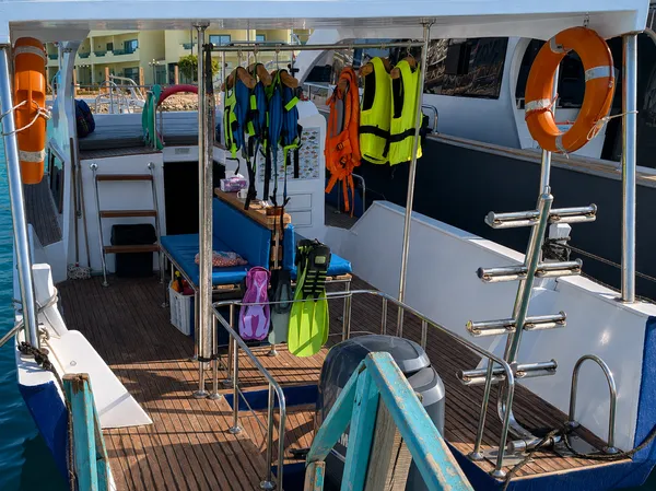 Blick über das Achterdeck mit Rettungswesten, Schnorchelausrüstung und Flossen an der Reling